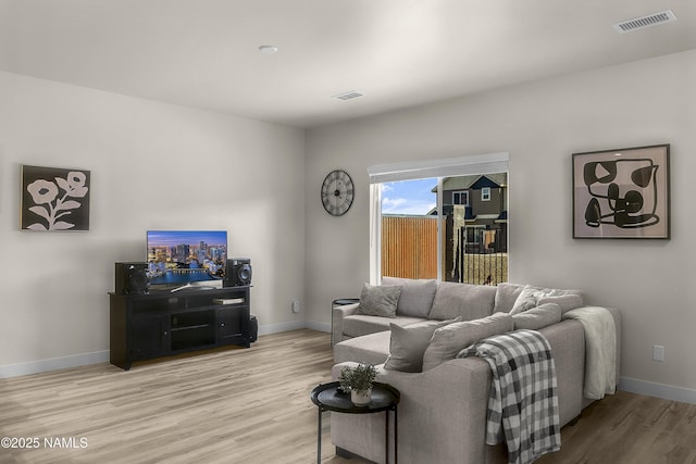 living area with visible vents, baseboards, and light wood-type flooring