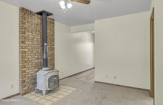 501 W Santa Fe Ave Unit 28, Flagstaff, AZ 86001 - unfurnished living room with a wood stove, a ceiling fan, light carpet, and baseboards