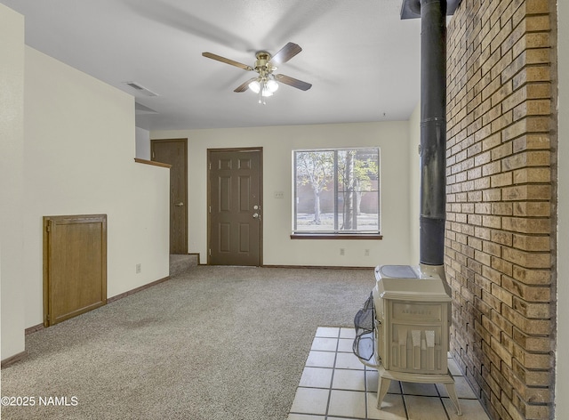 501 W Santa Fe Ave Unit 28, Flagstaff, AZ 86001 - living area featuring a wood stove, ceiling fan, light colored carpet, and baseboards