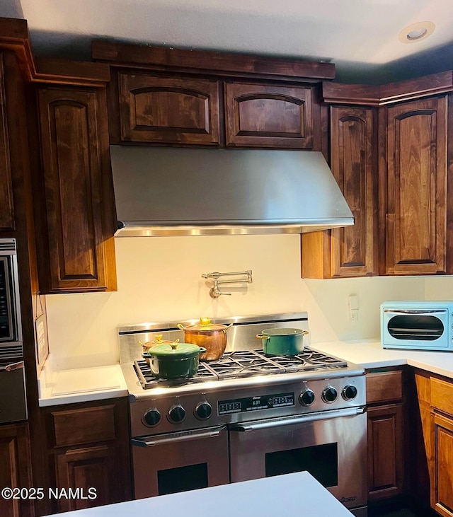 5070 N Weatherford Rd, Flagstaff, AZ 86001 - kitchen with exhaust hood, stainless steel appliances, and light countertops