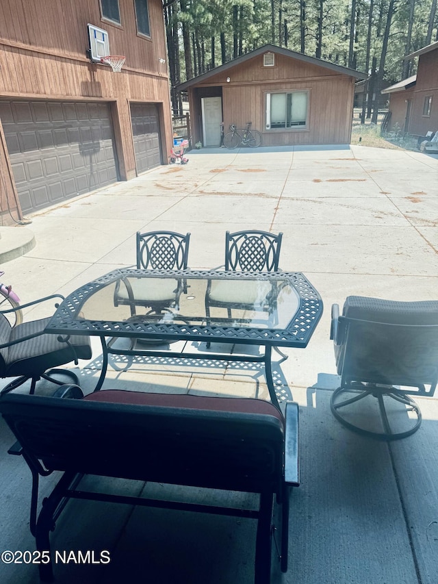 5070 N Weatherford Rd, Flagstaff, AZ 86001 - view of patio featuring outdoor dining area, a garage, and concrete driveway