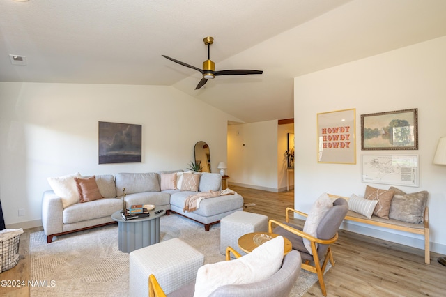 living room featuring ceiling fan, light wood-type flooring, and lofted ceiling