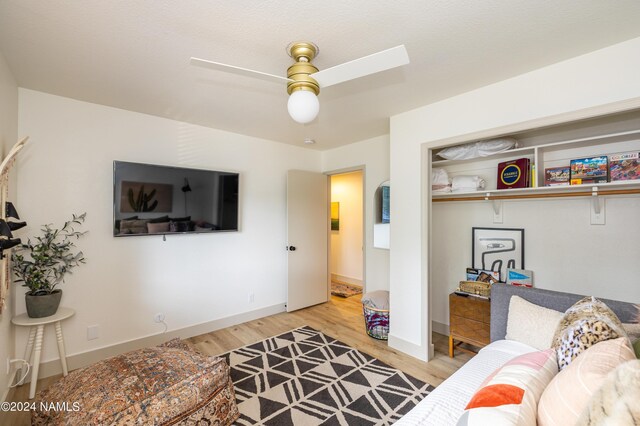 living room featuring light hardwood / wood-style floors and ceiling fan