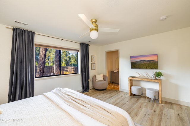 bedroom featuring ceiling fan, light hardwood / wood-style floors, and ensuite bathroom