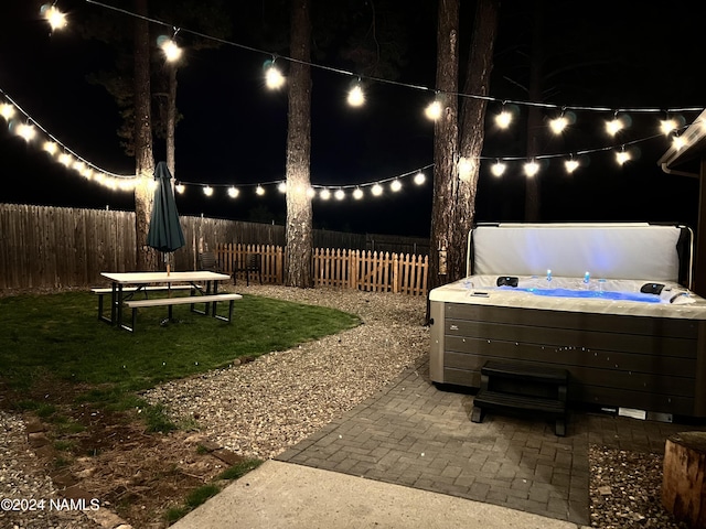 patio at night with a hot tub