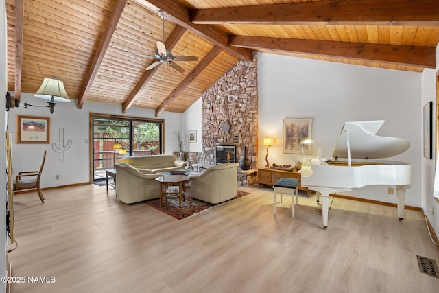 2468 N Strawberry Way, Flagstaff, AZ 86004 - living area with wood ceiling with exposed beams, wood finished floors, a stone fireplace, baseboards, and a ceiling fan