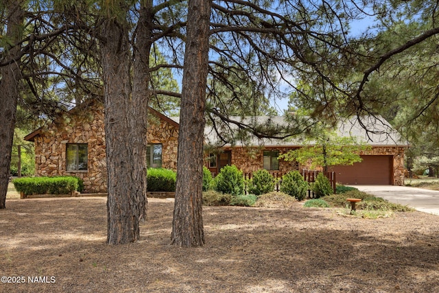 2468 N Strawberry Way, Flagstaff, AZ 86004 - view of property hidden behind natural elements with stone siding, a garage, and concrete driveway