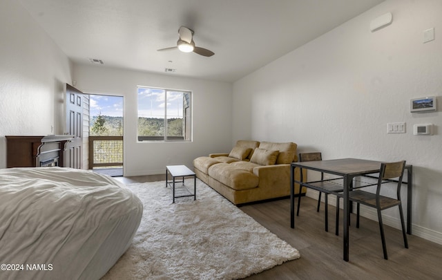 bedroom featuring access to exterior, ceiling fan, and dark hardwood / wood-style flooring