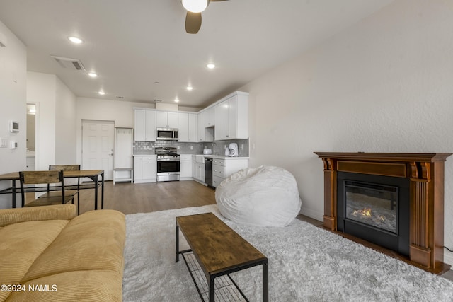 living room with ceiling fan and dark hardwood / wood-style floors