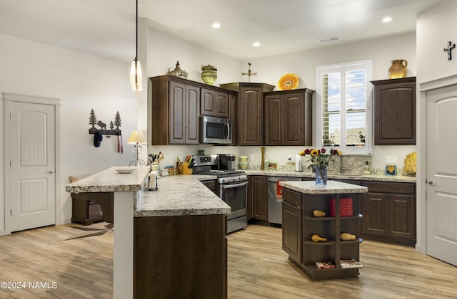 kitchen with stainless steel appliances, open shelves, dark brown cabinetry, light wood-style flooring, and a peninsula