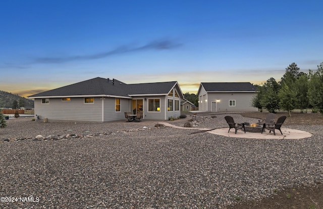 back of property at dusk featuring an outdoor fire pit and a patio area