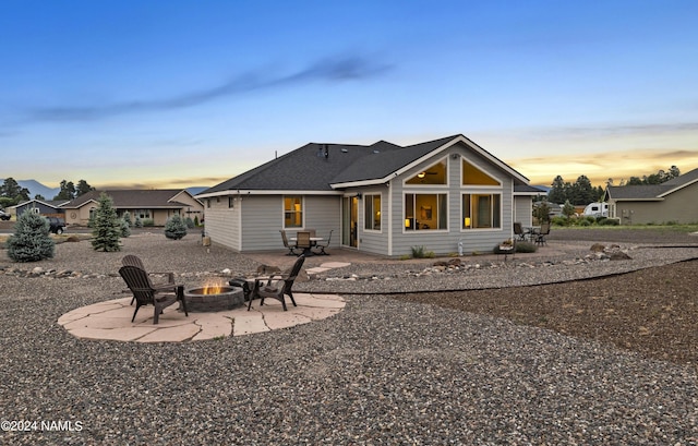 rear view of house with a patio and a fire pit