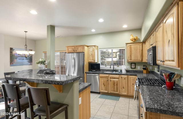 kitchen featuring a kitchen breakfast bar, pendant lighting, appliances with stainless steel finishes, light tile patterned flooring, and a notable chandelier