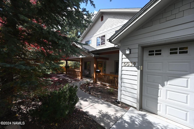 view of side of property featuring a garage and a porch