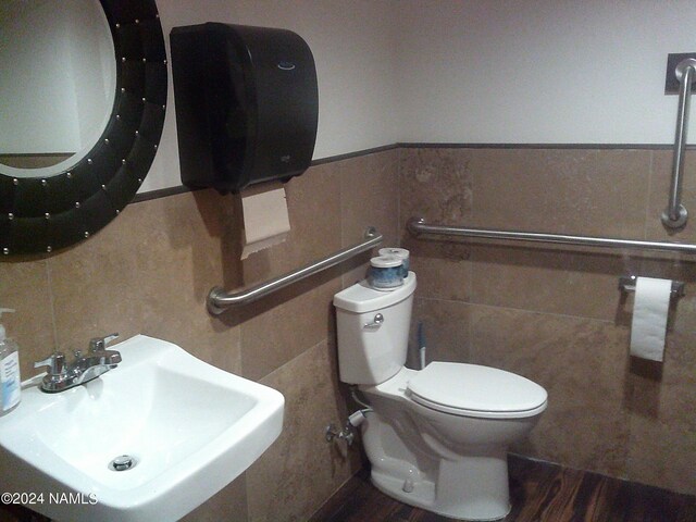 bathroom with sink, toilet, tile walls, and hardwood / wood-style flooring