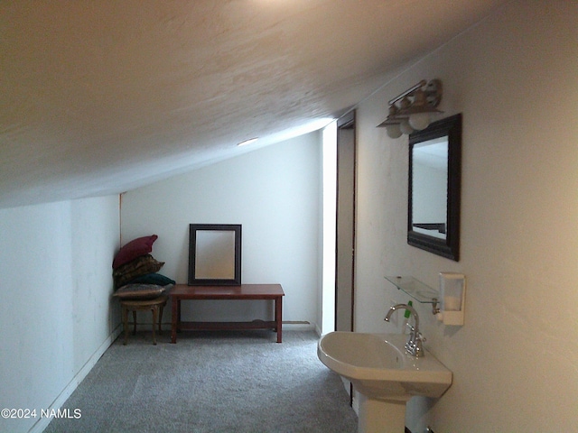 interior space with carpet floors, sink, and vaulted ceiling