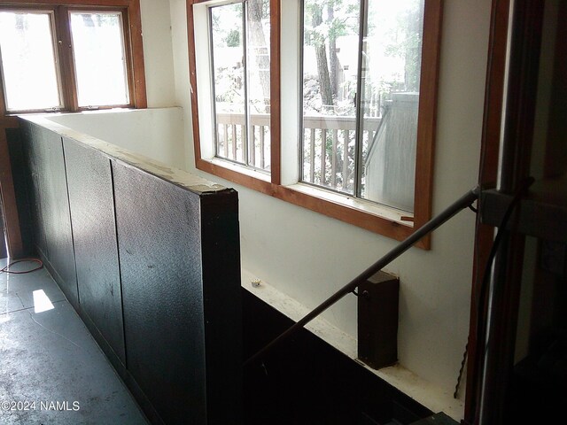 stairway featuring concrete floors and plenty of natural light