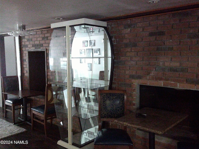 dining space featuring a brick fireplace and brick wall