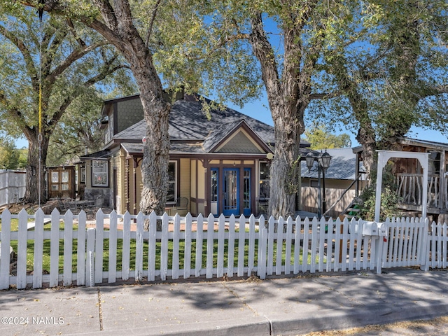 view of front of house with french doors and a front lawn