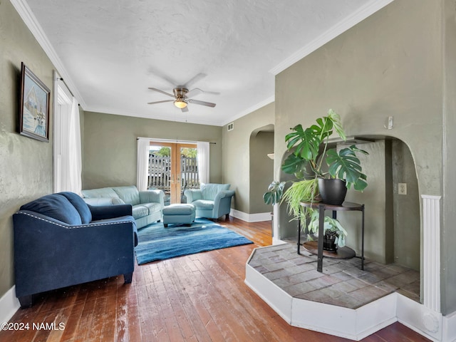 living room featuring a textured ceiling, wood-type flooring, french doors, ornamental molding, and ceiling fan