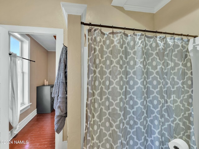 bathroom with hardwood / wood-style flooring and ornamental molding