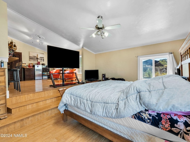 bedroom featuring light hardwood / wood-style floors, lofted ceiling, ceiling fan, and stainless steel refrigerator