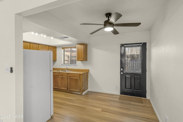501 W Santa Fe Ave Unit 3, Flagstaff, AZ 86001 - kitchen with visible vents, freestanding refrigerator, a sink, light wood-style floors, and brown cabinets