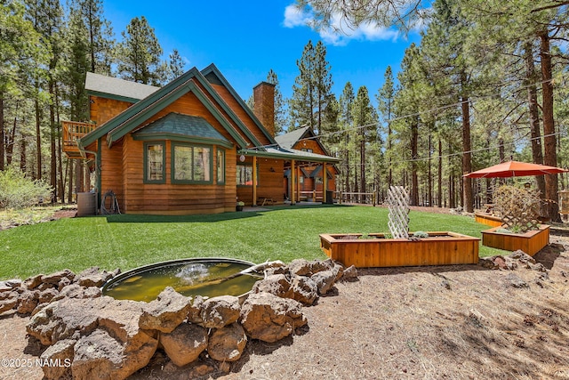435 N Laramy Ln, Parks, AZ 86018 - rear view of house with a chimney, a garden pond, a yard, and a vegetable garden