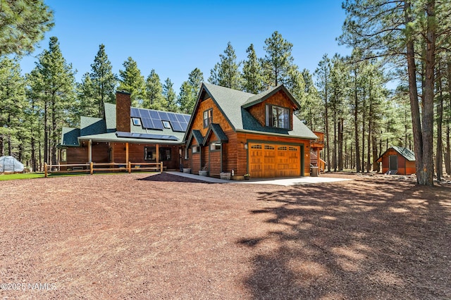 435 N Laramy Ln, Parks, AZ 86018 - view of front facade with roof mounted solar panels, dirt driveway, covered porch, a garage, and a chimney