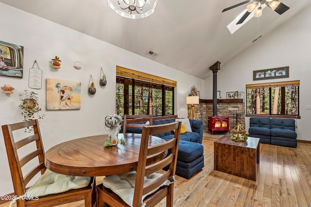 435 N Laramy Ln, Parks, AZ 86018 - dining area featuring a wood stove, light wood-style floors, a ceiling fan, high vaulted ceiling, and a skylight