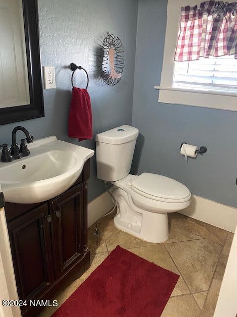 bathroom with vanity, toilet, and tile patterned flooring