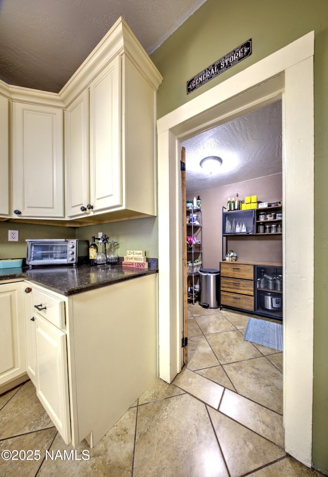 8134 Mclaws Ave, Joseph City, AZ 86032 - kitchen with cream cabinetry, a textured ceiling, and light tile patterned floors