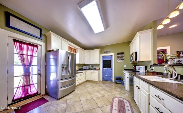 8134 Mclaws Ave, Joseph City, AZ 86032 - kitchen with appliances with stainless steel finishes, a sink, dark countertops, white cabinets, and light tile patterned floors
