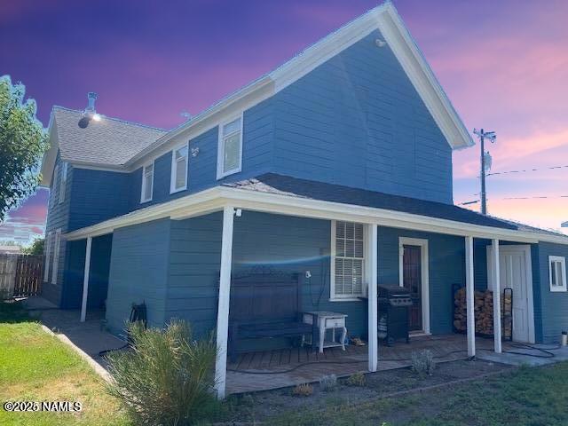 back house at dusk with a patio