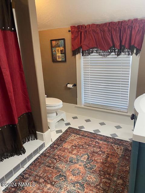 bathroom with curtained shower and toilet