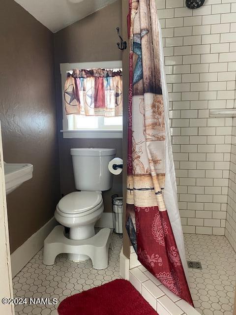 bathroom with a shower with curtain and toilet