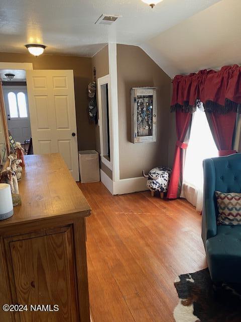 interior space featuring lofted ceiling and hardwood / wood-style floors