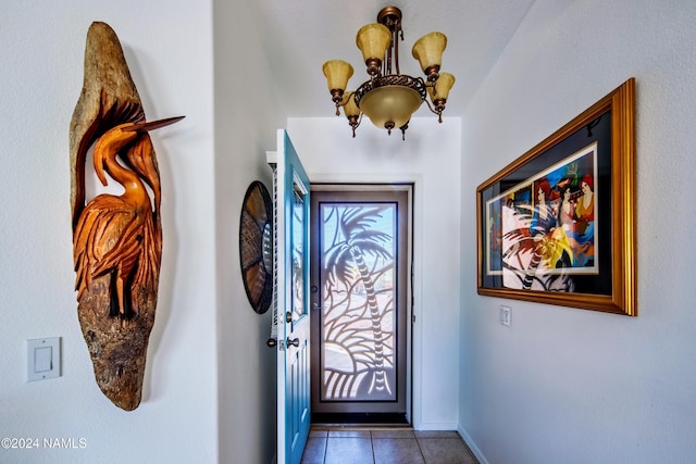 entryway with an inviting chandelier and light tile patterned floors