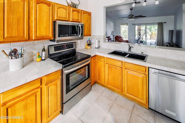 kitchen featuring sink, light tile patterned flooring, decorative backsplash, and stainless steel appliances