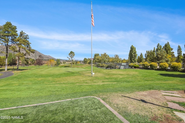 surrounding community with a mountain view and a lawn