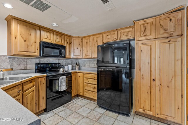 kitchen with tasteful backsplash, sink, and black appliances