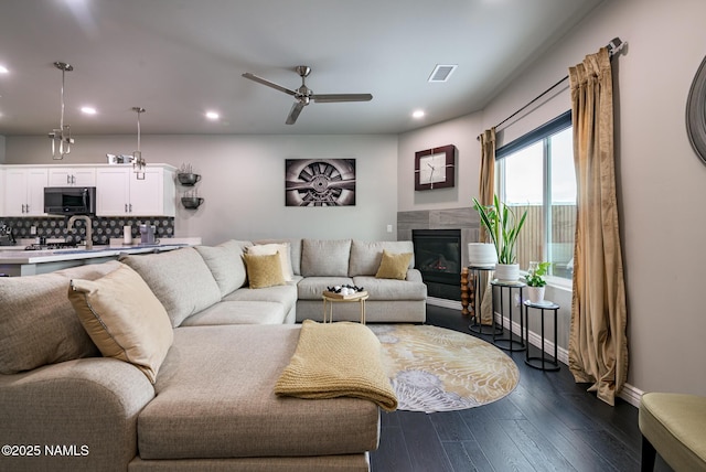 living room featuring dark hardwood / wood-style flooring and ceiling fan