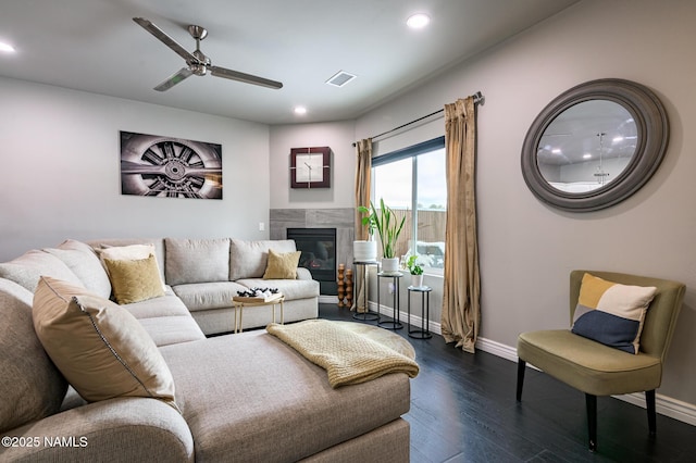 living room with a premium fireplace, ceiling fan, and dark hardwood / wood-style flooring