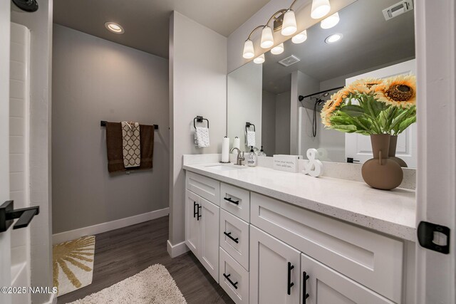 bathroom featuring vanity, wood-type flooring, and walk in shower