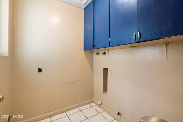 laundry area featuring hookup for an electric dryer, light tile patterned floors, and cabinets