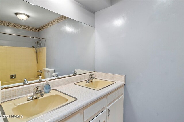 full bathroom with tiled shower / bath combo, toilet, and vanity