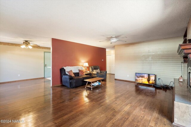 living room with wood-type flooring, a textured ceiling, and ceiling fan