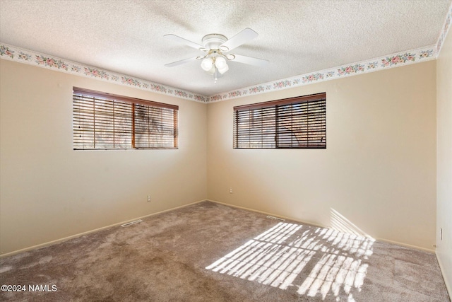 carpeted empty room with ceiling fan and a textured ceiling