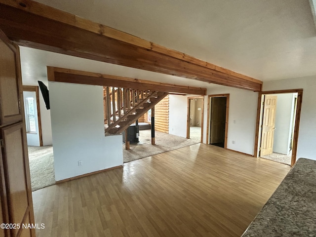 8120 N Cassity Trl, Williams, AZ 86046 - unfurnished living room with wood finished floors, stairs, beam ceiling, and baseboards