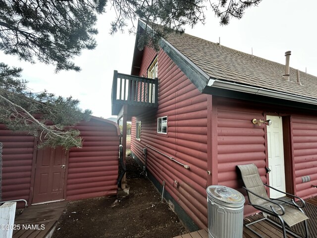 8120 N Cassity Trl, Williams, AZ 86046 - view of side of home featuring a shingled roof, log veneer siding, and a balcony